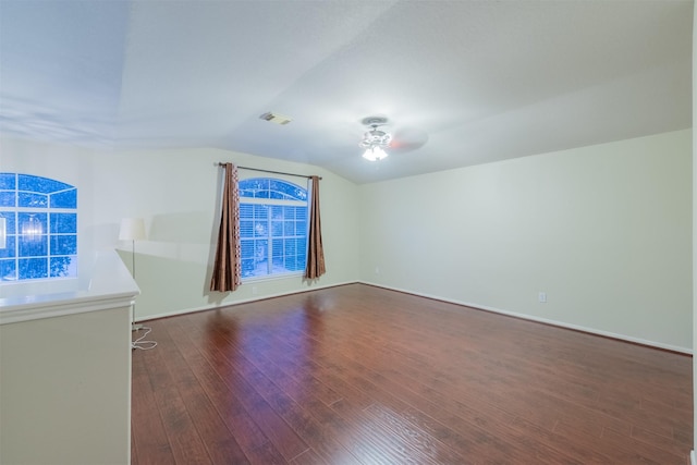 unfurnished room featuring visible vents, ceiling fan, dark wood finished floors, and vaulted ceiling
