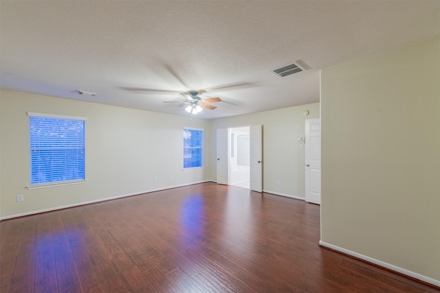 spare room featuring visible vents, ceiling fan, wood finished floors, and baseboards