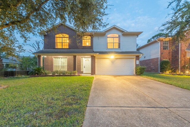 traditional-style home with brick siding, driveway, a front lawn, and a garage
