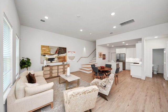 1049 Glenn Ave, Houston, TX 77088 - living room featuring visible vents, light wood-type flooring, recessed lighting, and stairs