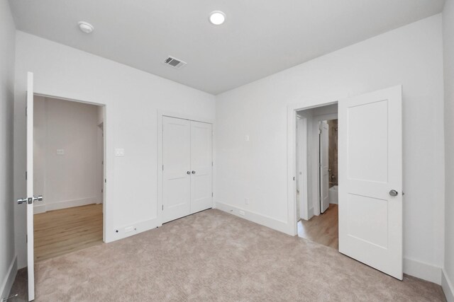 1049 Glenn Ave, Houston, TX 77088 - unfurnished bedroom with a closet, baseboards, recessed lighting, visible vents, and light colored carpet