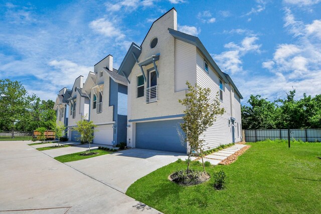 1049 Glenn Ave, Houston, TX 77088 - view of property exterior featuring a garage, stucco siding, a lawn, fence, and driveway