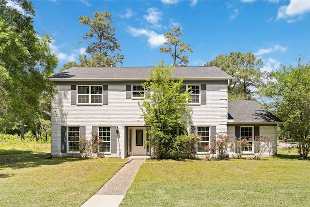 colonial inspired home featuring a front lawn