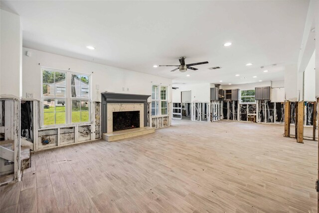unfurnished living room featuring light wood-style flooring, visible vents, recessed lighting, a ceiling fan, and a fireplace