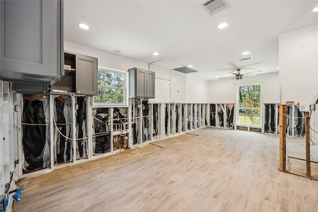 empty room with light wood-style flooring, visible vents, and a wealth of natural light
