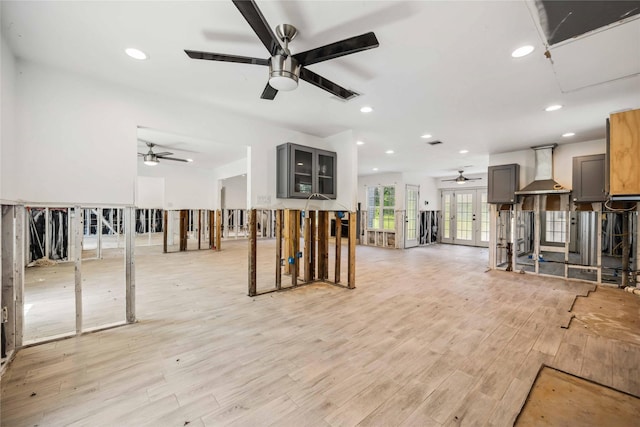 unfurnished living room featuring ceiling fan, french doors, light wood finished floors, and recessed lighting