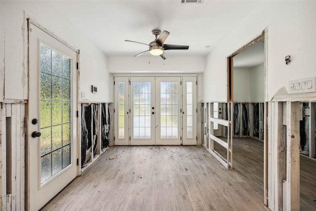 interior space with a ceiling fan, a healthy amount of sunlight, french doors, and light wood-style floors