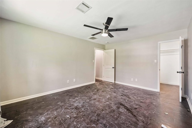 unfurnished bedroom featuring a spacious closet, visible vents, a ceiling fan, and baseboards