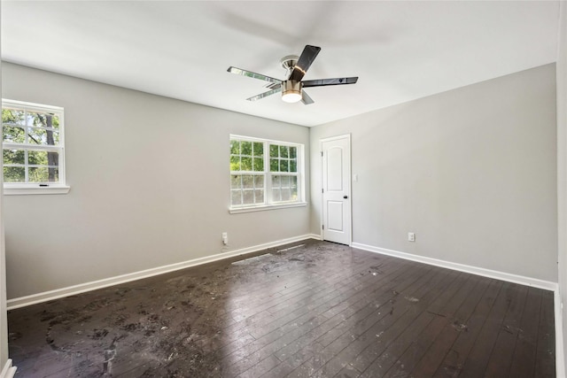 unfurnished room featuring ceiling fan, baseboards, and dark wood-type flooring