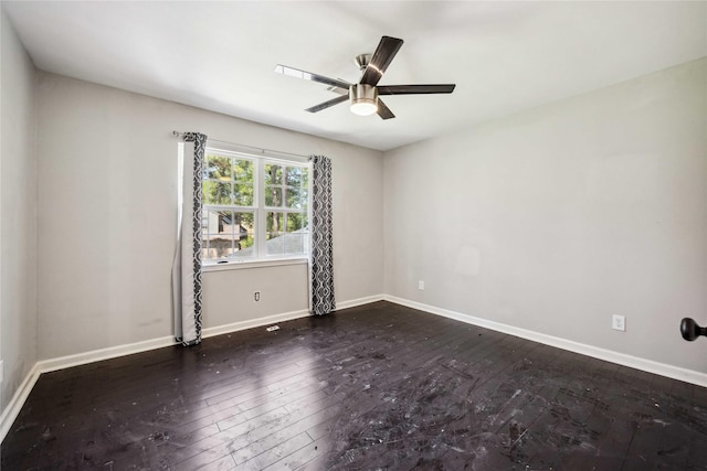 empty room featuring baseboards, a ceiling fan, and dark wood-style floors