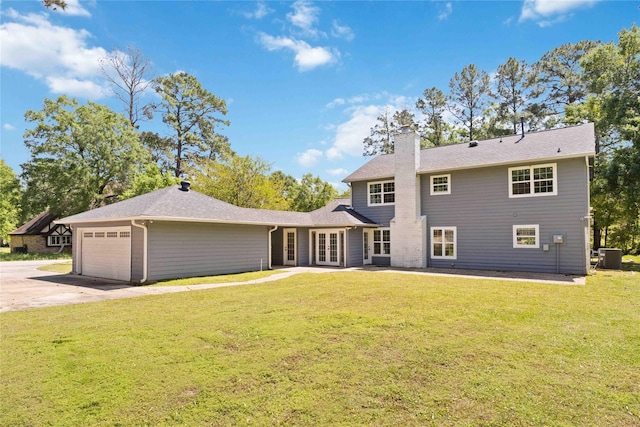 view of front of house with concrete driveway, a front lawn, a chimney, french doors, and a garage