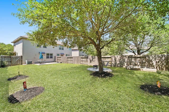 view of yard with a fenced backyard, central AC unit, and a patio area