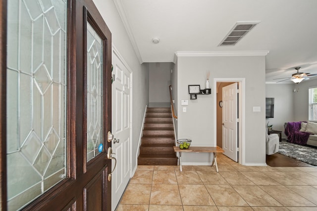entryway featuring visible vents, crown molding, baseboards, stairs, and light tile patterned flooring