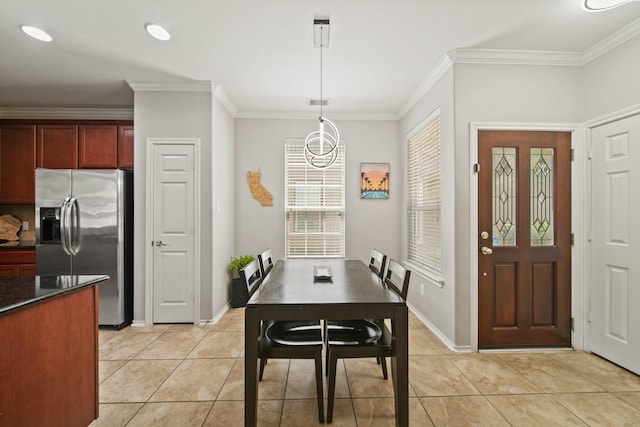 dining space featuring baseboards, ornamental molding, and light tile patterned floors