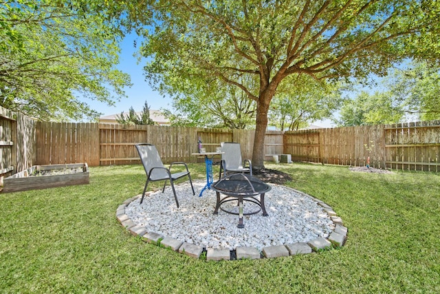 view of yard with a fenced backyard, a fire pit, and a vegetable garden
