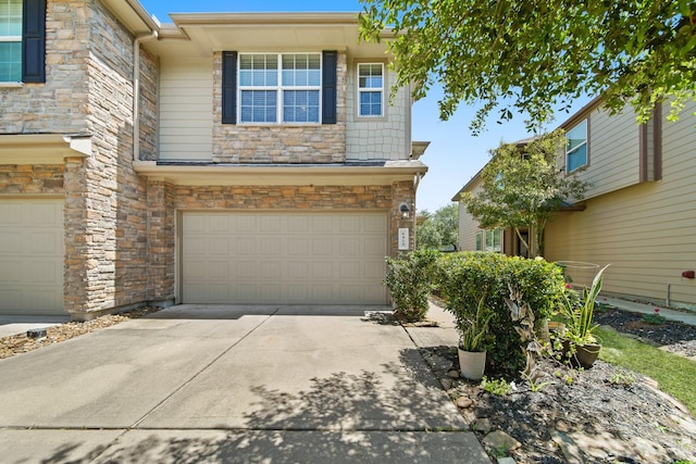 view of front of house featuring a garage, stone siding, and concrete driveway