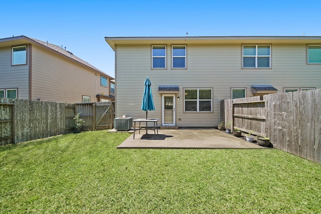 rear view of property featuring a lawn, central AC unit, a gate, a patio area, and a fenced backyard