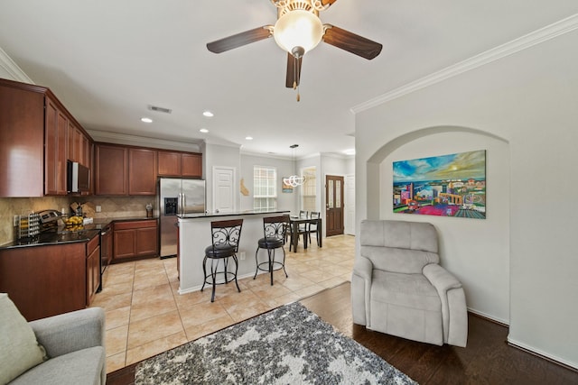 living room featuring visible vents, crown molding, ceiling fan, recessed lighting, and light wood finished floors