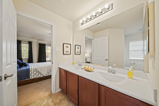 ensuite bathroom with double vanity, a sink, connected bathroom, and tile patterned flooring