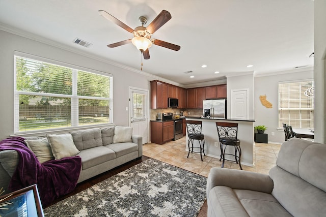 living room with a ceiling fan, recessed lighting, light tile patterned floors, visible vents, and ornamental molding