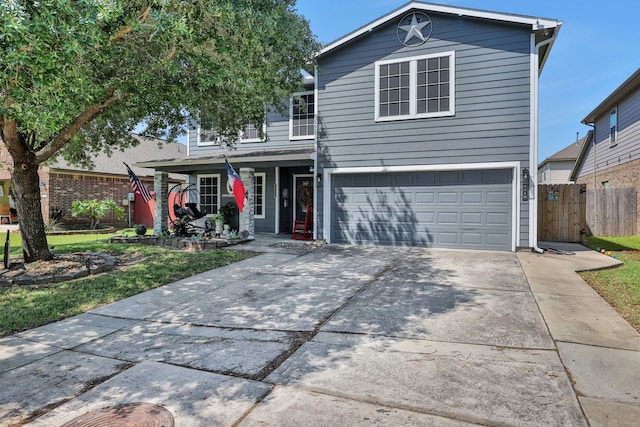 traditional-style house featuring fence, driveway, and a garage