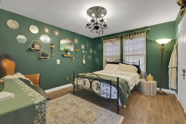 8319 Lemongrass Ave, Baytown, TX 77521 - bedroom with an inviting chandelier, wood finished floors, and baseboards