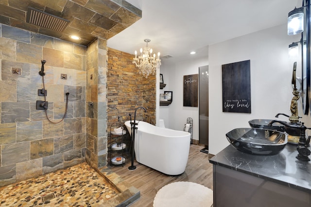 8319 Lemongrass Ave, Baytown, TX 77521 - bathroom with an inviting chandelier, a walk in shower, vanity, a soaking tub, and wood finished floors
