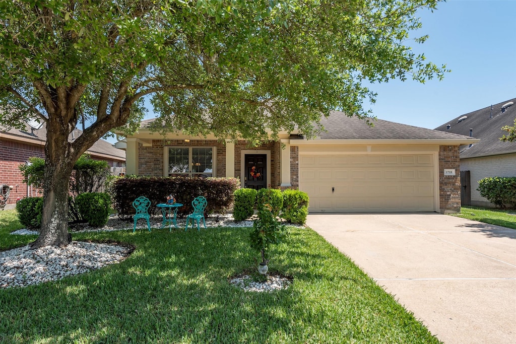 1710 Macclesby Ln, Houston, TX 77049 - obstructed view of property featuring brick siding, a front yard, an attached garage, and driveway