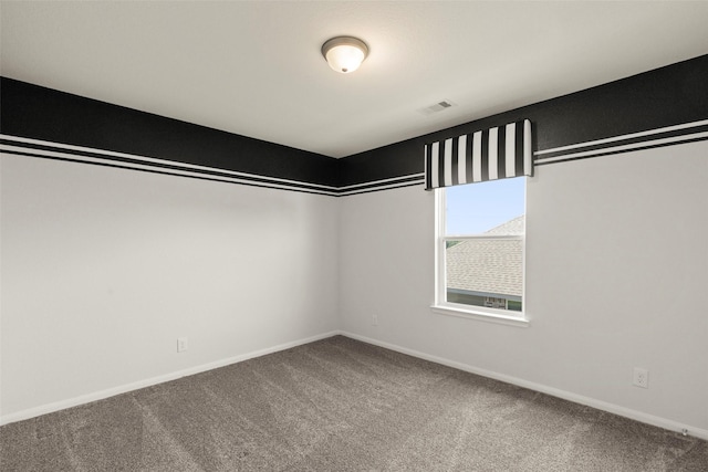 spare room featuring visible vents, baseboards, and carpet flooring