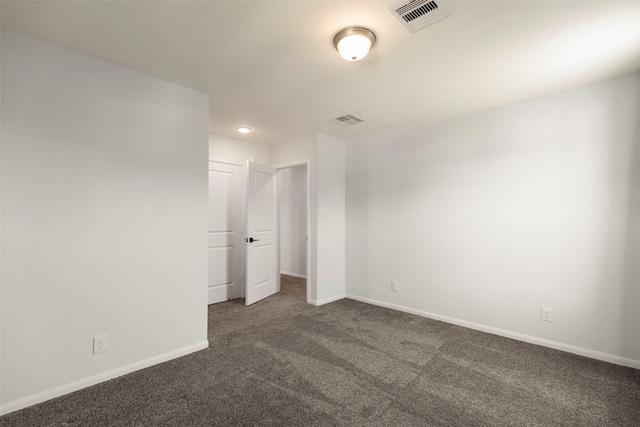 spare room with carpet flooring, baseboards, and visible vents