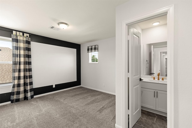 cinema with a sink, visible vents, baseboards, and dark colored carpet