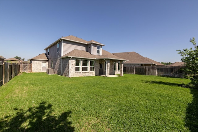 rear view of property with brick siding, a fenced backyard, central AC unit, and a lawn