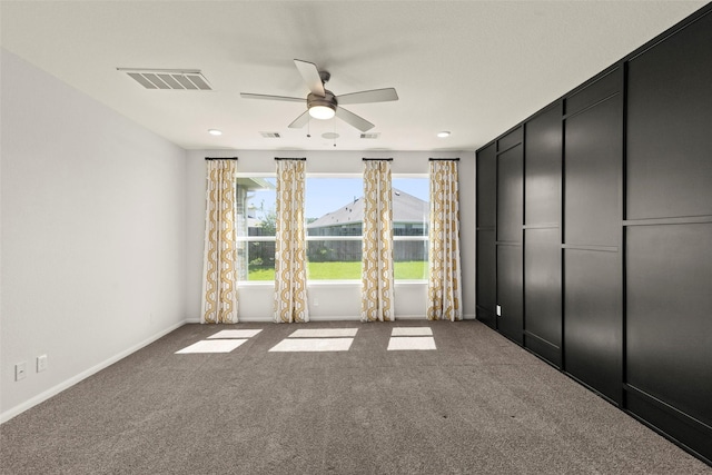 unfurnished bedroom with visible vents, baseboards, ceiling fan, and carpet