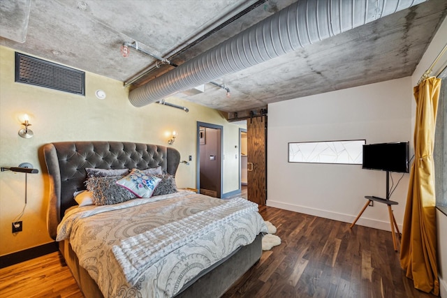 bedroom featuring baseboards, wood finished floors, and visible vents