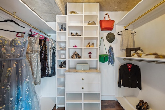 walk in closet with dark wood-style floors