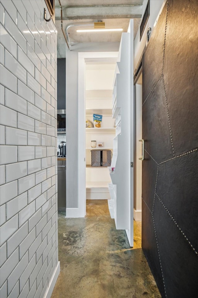 hall featuring concrete floors and visible vents