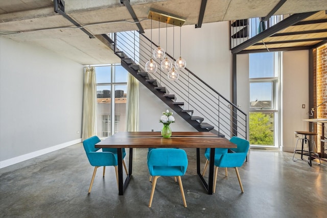 dining area featuring baseboards, concrete flooring, and stairs