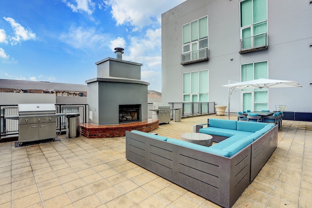 view of patio / terrace with grilling area and an outdoor living space with a fireplace