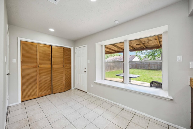 interior space with a wealth of natural light, recessed lighting, baseboards, and a textured ceiling
