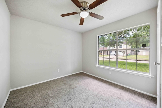 carpeted empty room with baseboards and a ceiling fan