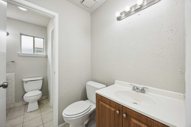 bathroom featuring toilet, vanity, tile patterned flooring, and visible vents