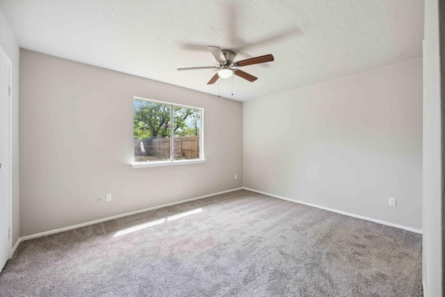 empty room featuring carpet flooring, baseboards, and ceiling fan