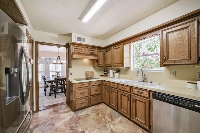 kitchen with stainless steel appliances, a sink, visible vents, an inviting chandelier, and light countertops