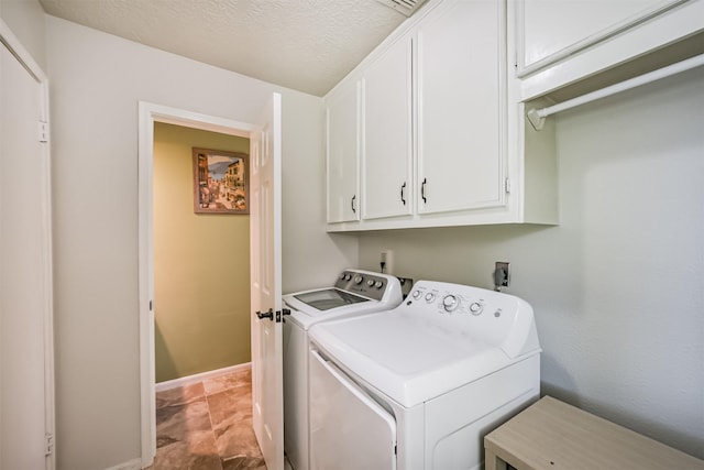 clothes washing area with baseboards, independent washer and dryer, and cabinet space