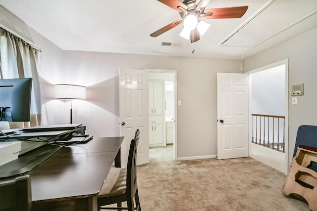 home office with a ceiling fan, attic access, light colored carpet, baseboards, and visible vents