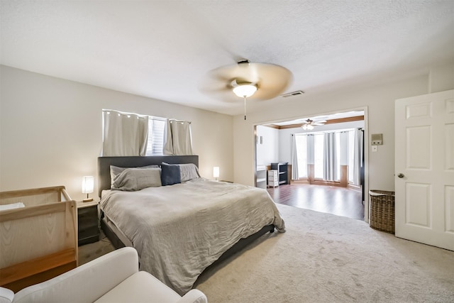 bedroom with ceiling fan, carpet flooring, multiple windows, and visible vents