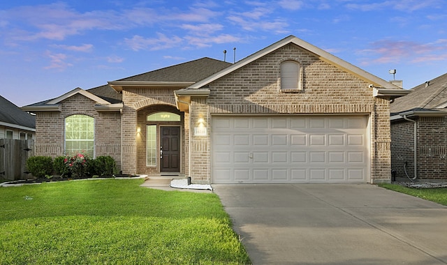 view of front facade with a front lawn, driveway, fence, brick siding, and a garage