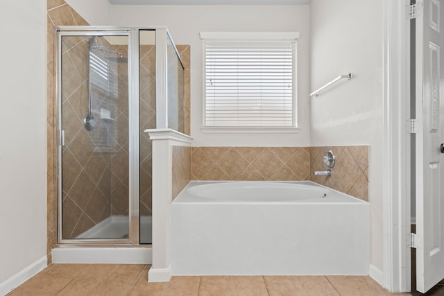 full bath with baseboards, a garden tub, tile patterned flooring, and a stall shower