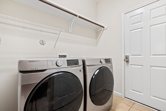 washroom featuring independent washer and dryer, laundry area, and light tile patterned flooring