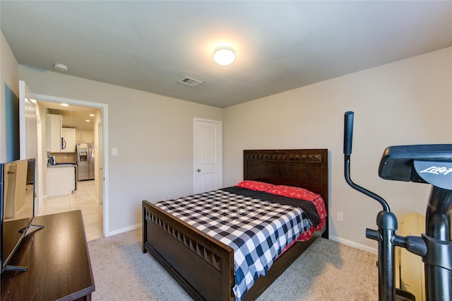 bedroom featuring stainless steel fridge with ice dispenser, visible vents, light colored carpet, and baseboards